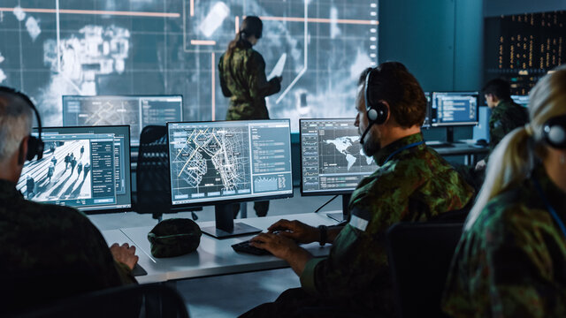 A secure operations room with analysts and monitoring screens